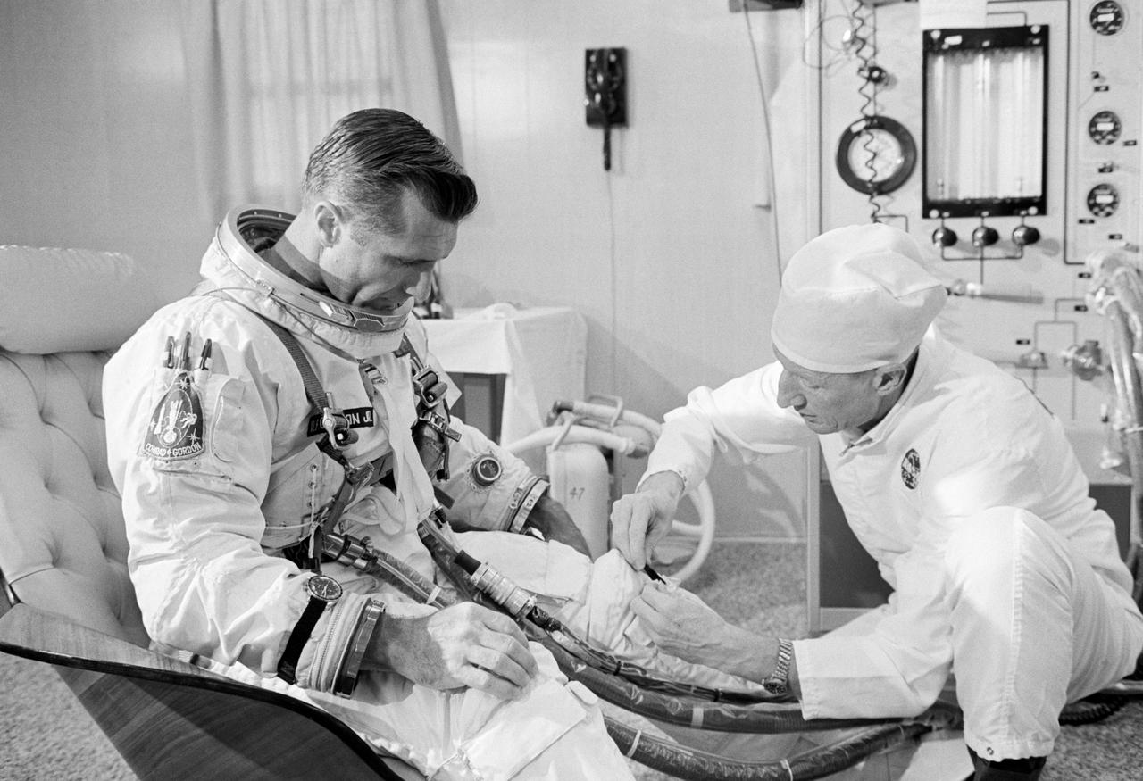Astronaut Richard F. Gordon Jr., pilot of the Gemini-11 spaceflight, undergoes suiting up operations in the Launch Complex 16 suit trailer during the Gemini-11 prelaunch countdown. At right is suit technician Clyde Teague